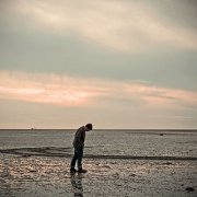 lonley man wlaking on a beach